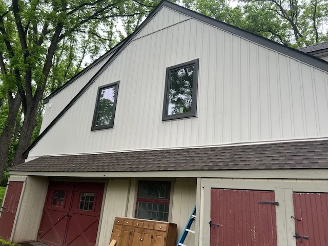 Siding installation on residential building in Bucks County, featuring premium materials, new windows, and a garage with red doors, highlighting Franco Roofing & Siding's expertise in home exterior enhancement.